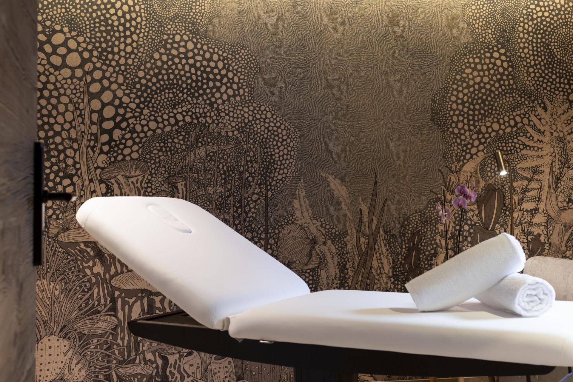 Private treatment room with adjustable massage table and integrated face cradle