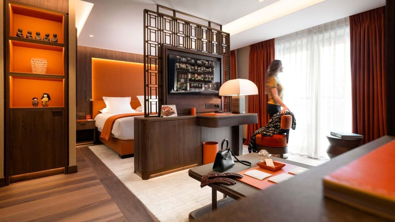 Suite with king bed and room divider featuring integrated TV and desk