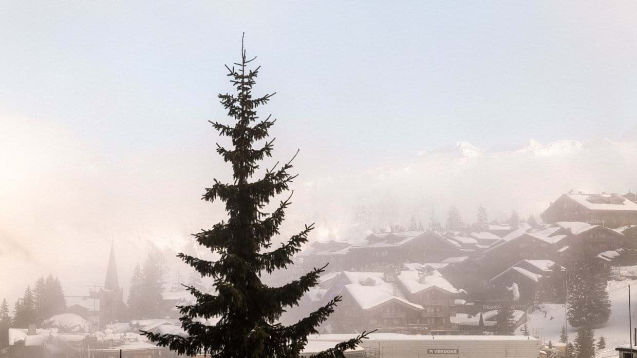 Alpine village view overlooking snow-covered chalets and misty mountain peaks