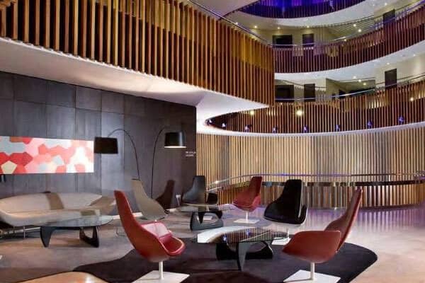 Communal lounge with swivel seating and multi-story circular atrium