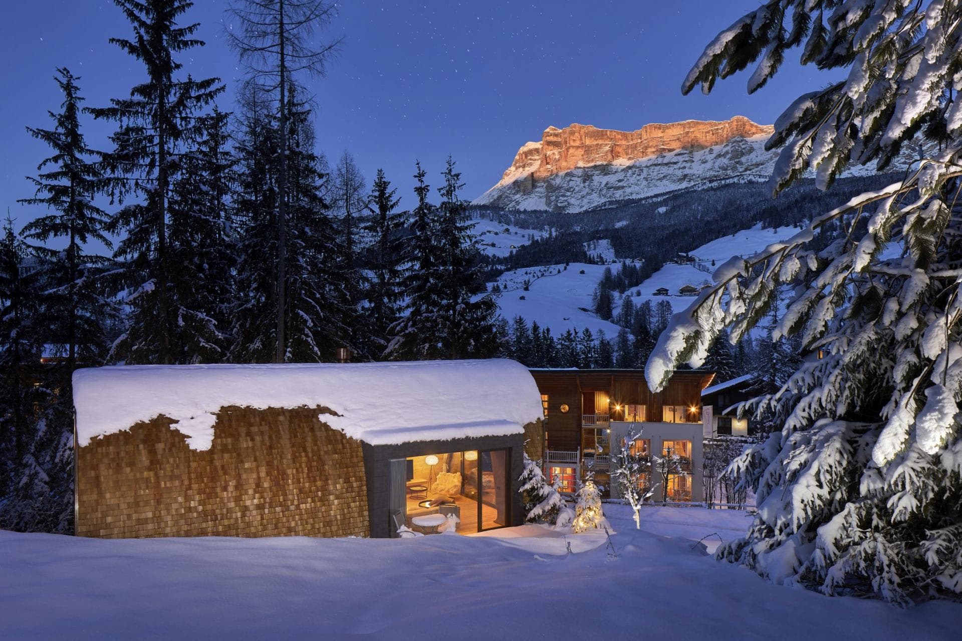 Cabin exterior with floor-to-ceiling windows and Dolomites mountain views