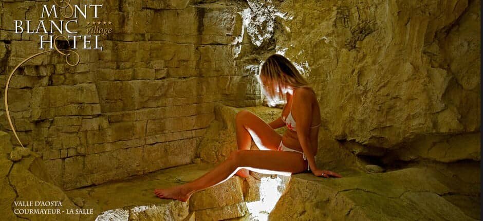 Thermal spa grotto with natural rock walls and carved seating