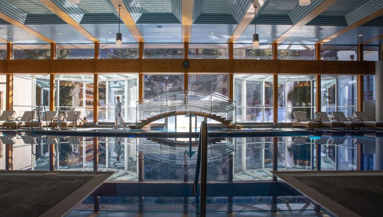 Indoor heated pool with bridge access to sunroom lounge