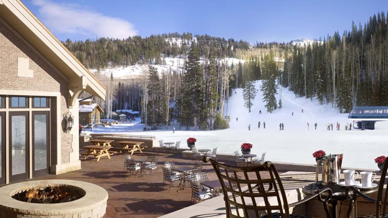 Outdoor terrace with fire pit and views of active ski slopes