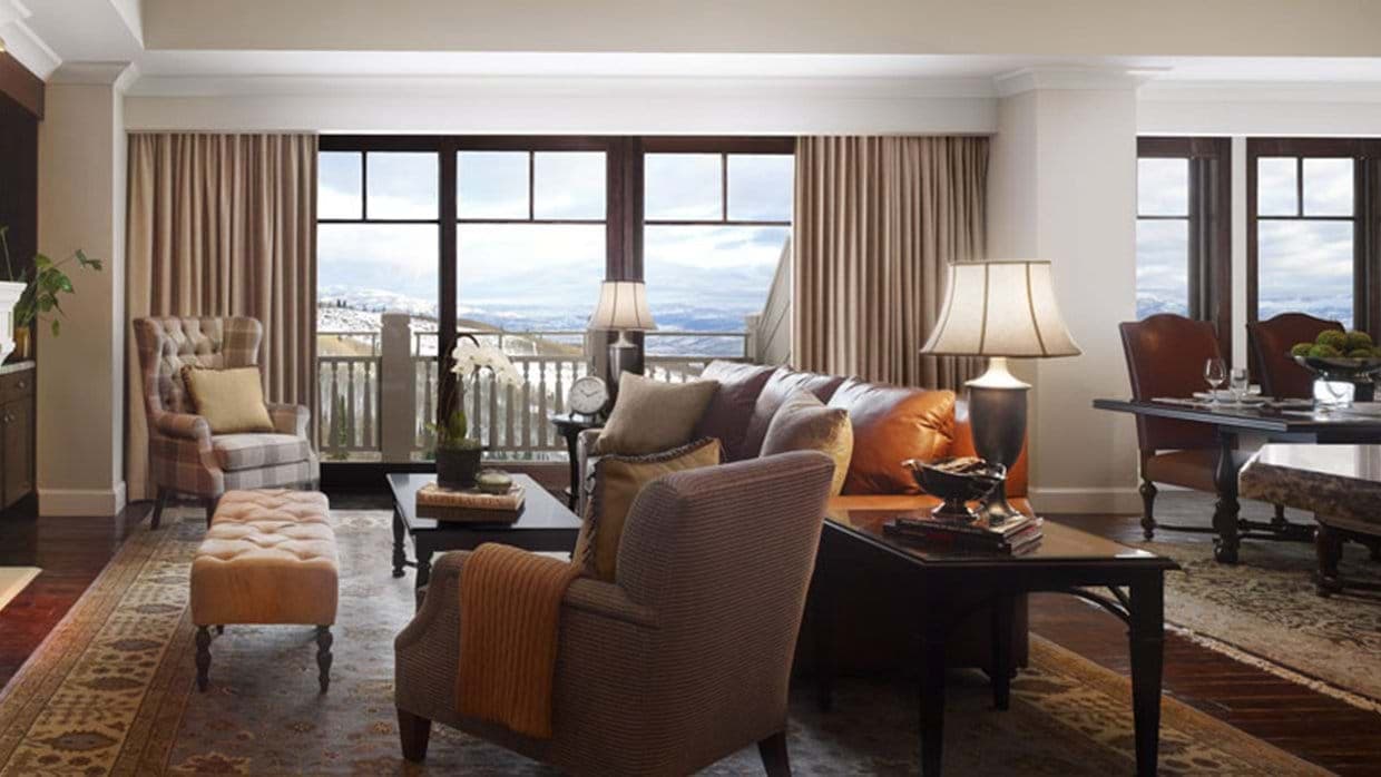 Open-plan living and dining area with balcony and mountain views