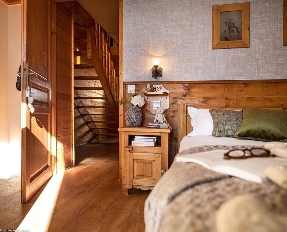 Bedroom with wood paneling and direct access to wooden staircase