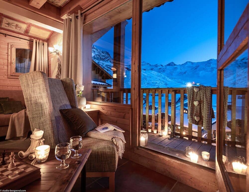 Seating area with private balcony and floor-to-ceiling mountain views