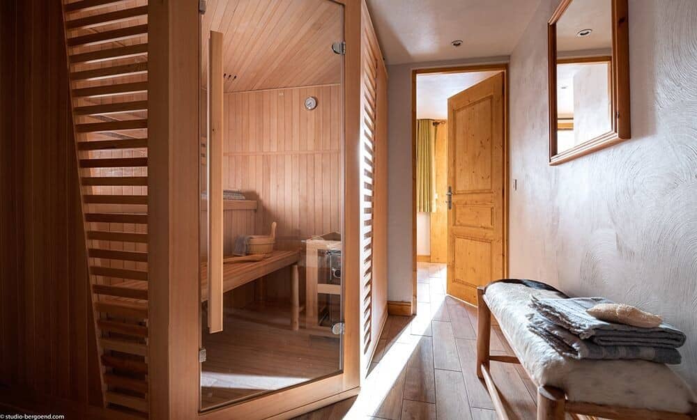 Indoor sauna with glass door and wood bench seating