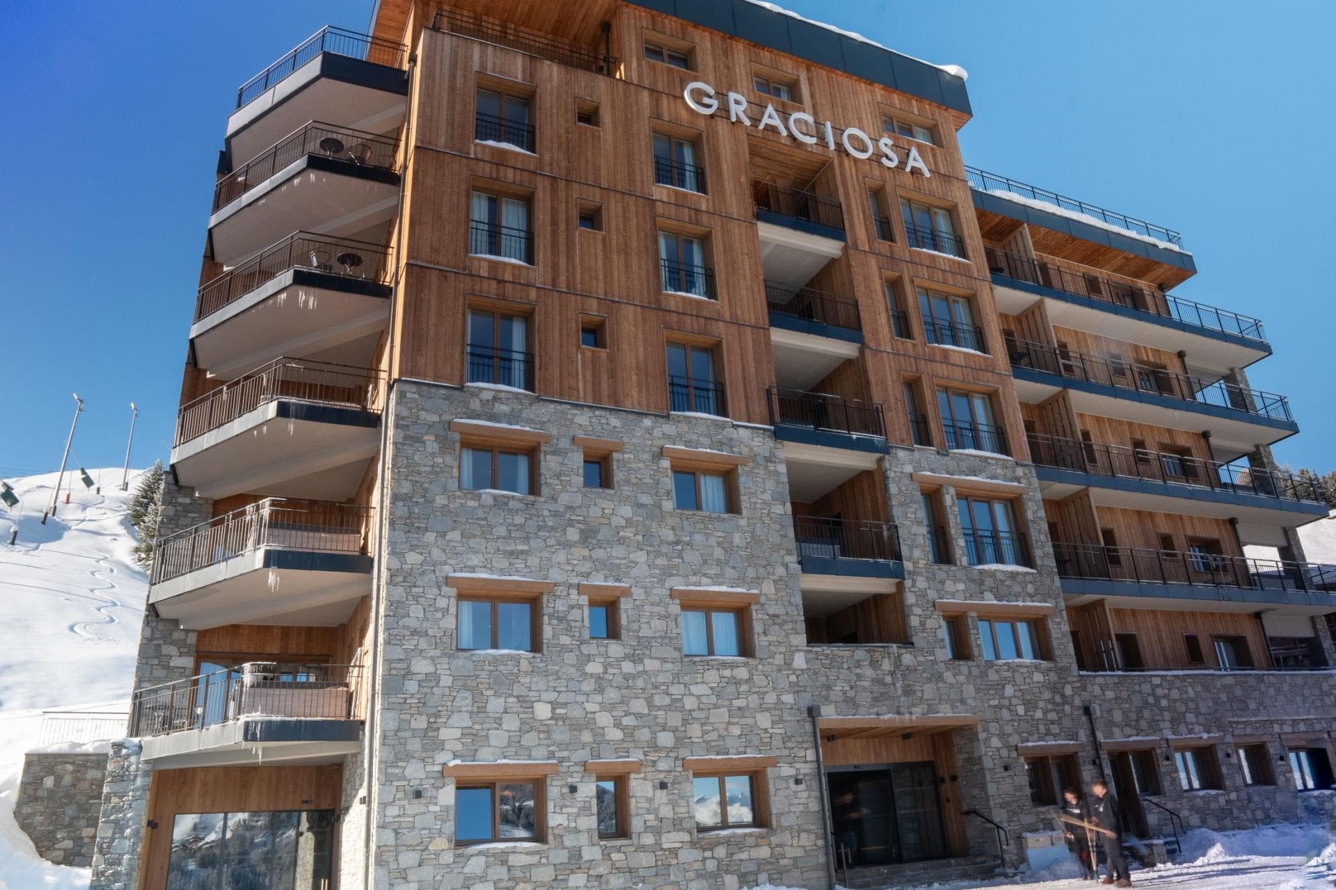 Ski-in/ski-out chalet exterior featuring private balconies and stone facade