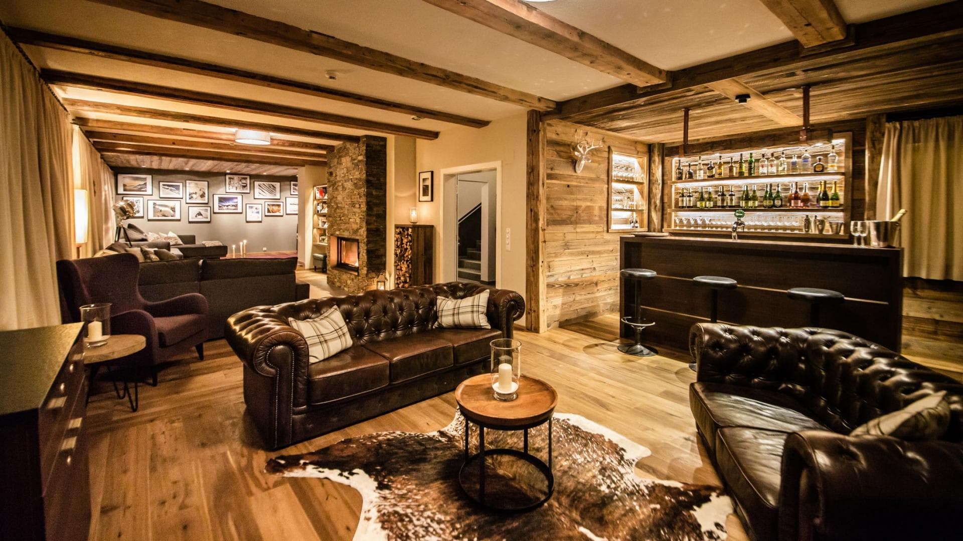 Lower level lounge with full bar, stone fireplace, and leather seating