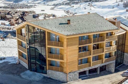 Timber chalet exterior with private balconies and floor-to-ceiling glass windows