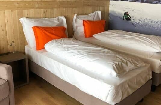 Bedroom with two twin beds and wood-paneled walls