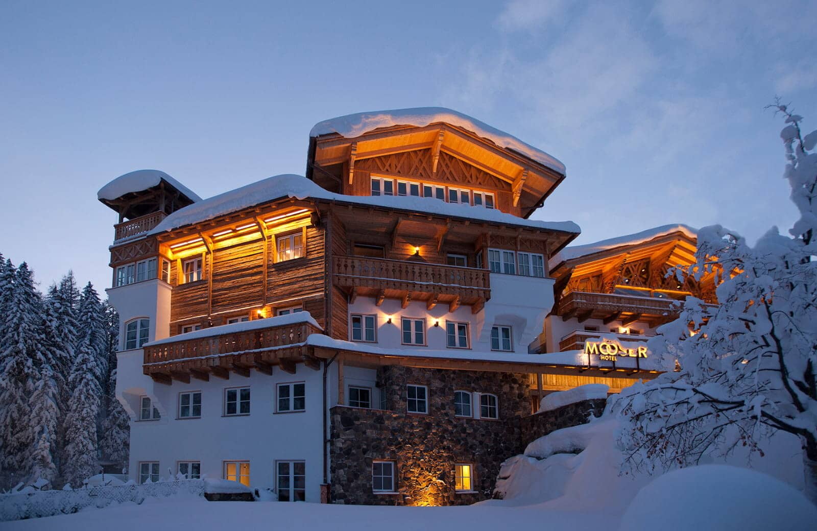 Alpine hotel exterior featuring private balconies and traditional timber construction