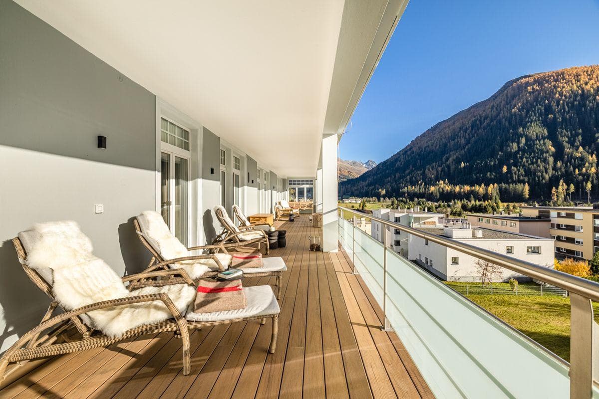Covered balcony with lounge chairs and mountain valley views