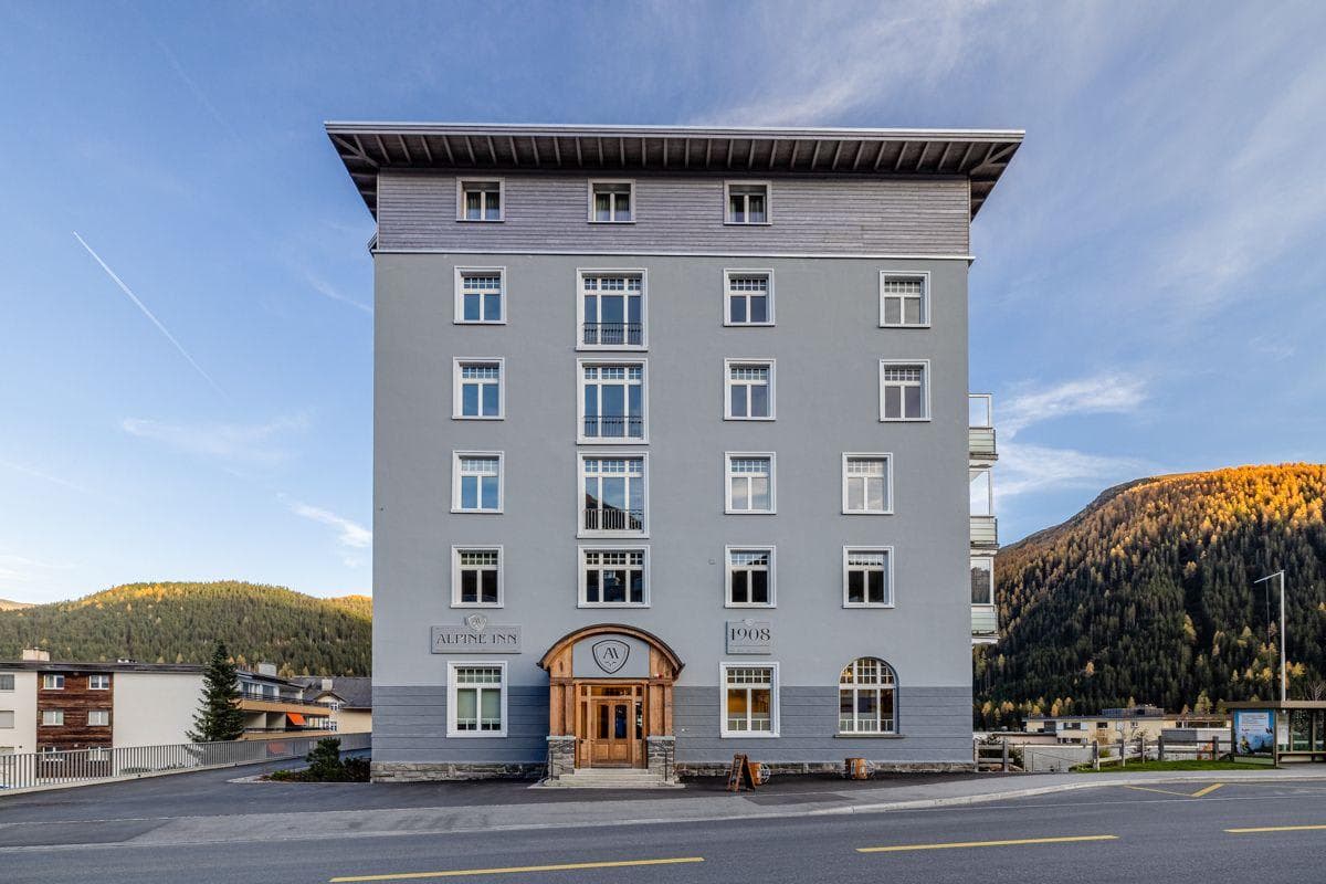 Alpine Inn exterior; historic 1908 building with mountain backdrop