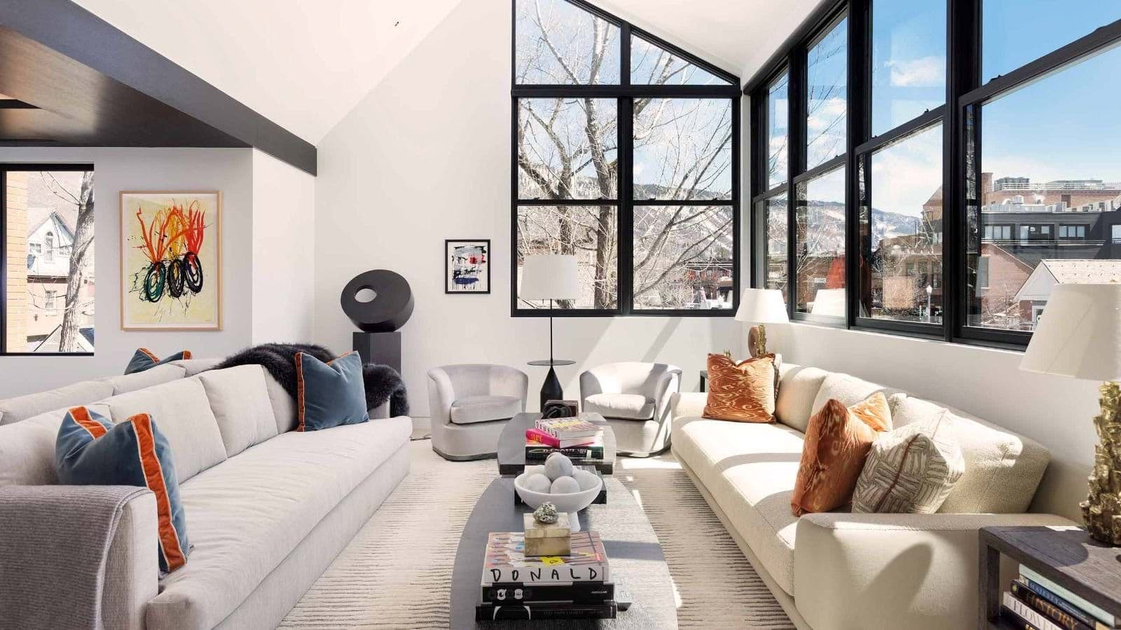 Living area with floor-to-ceiling windows and mountain town views