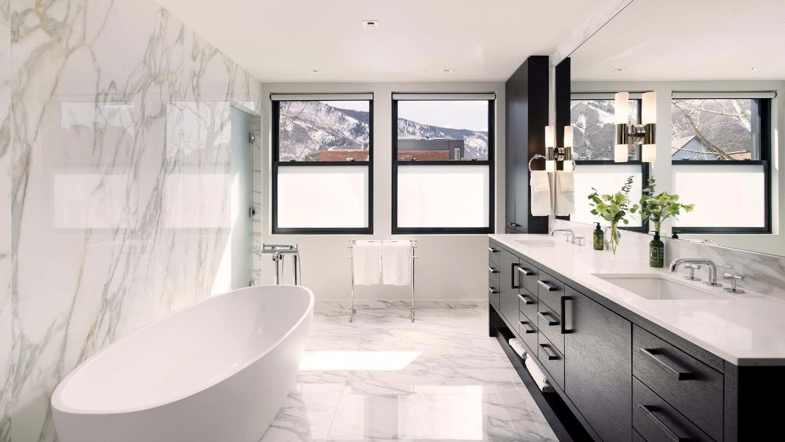 Bathroom with dual vanity, soaking tub, and mountain views