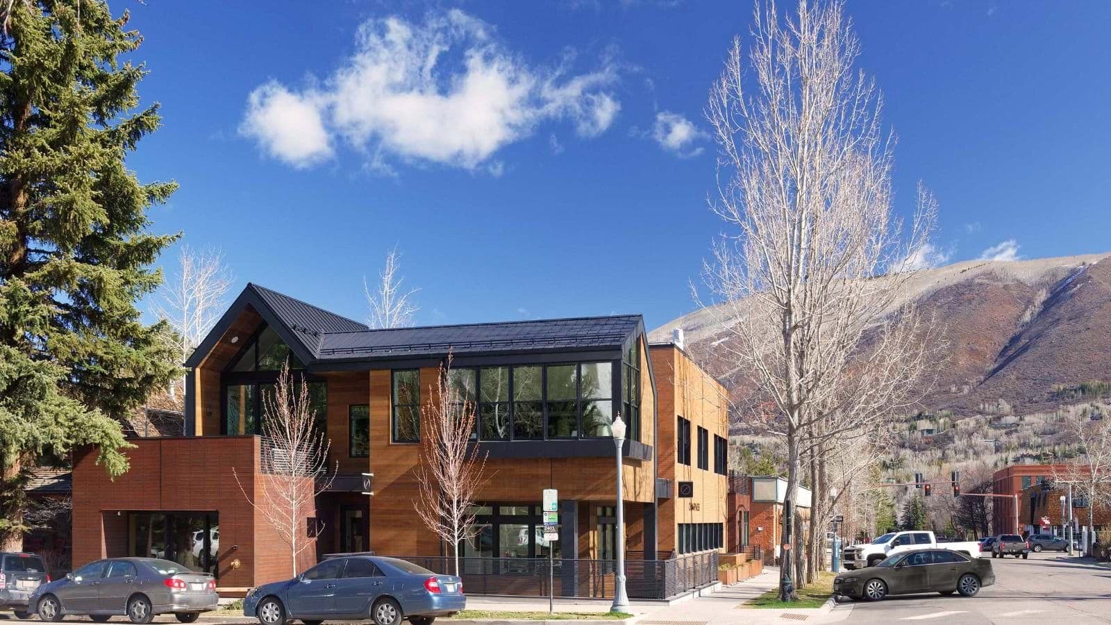 Building exterior with street parking and mountain backdrop