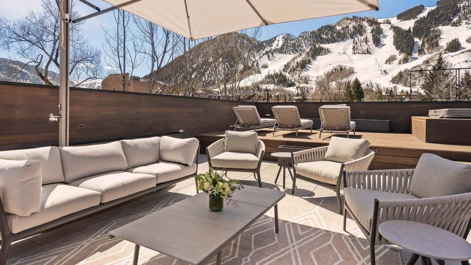 Rooftop terrace with fire pit, lounge seating, and ski mountain views