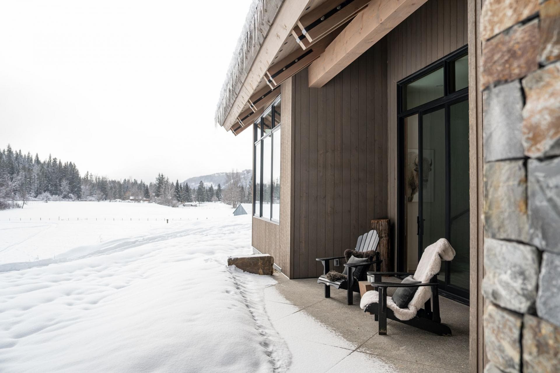 Covered patio with Adirondack chairs and snowy meadow views