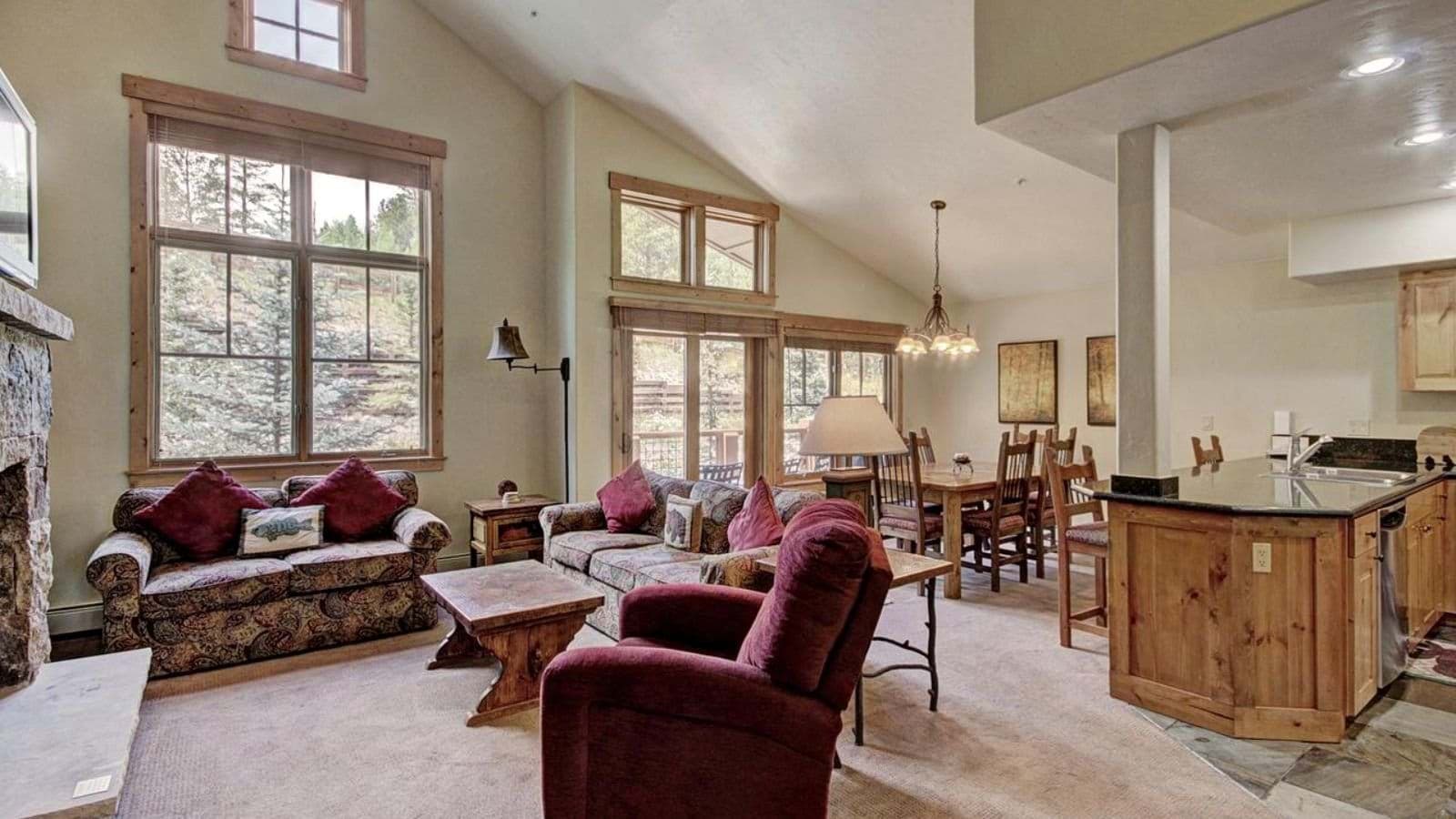Open living area with vaulted ceilings, stone fireplace, and seating for 6