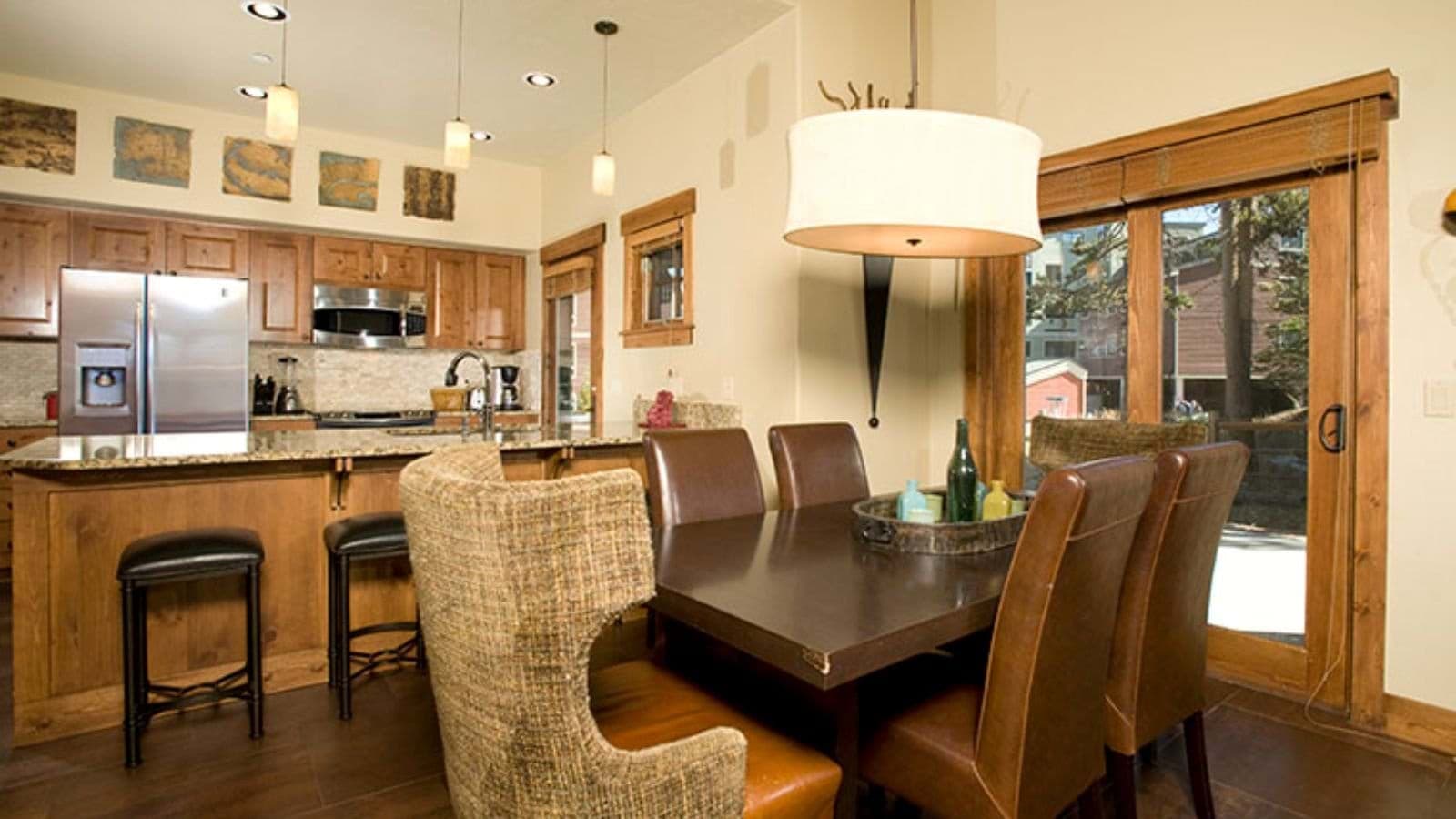 Open-plan dining area and kitchen with breakfast bar and deck access
