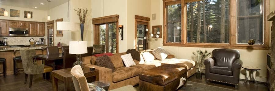 Open living area with sectional seating and forest views