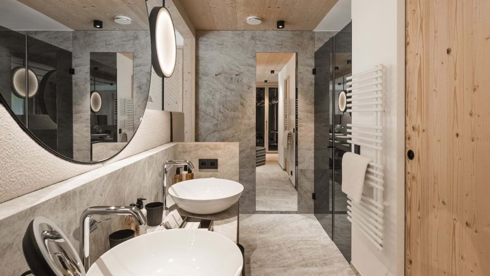 Bathroom with dual vessel sinks, heated towel rail, and walk-in shower