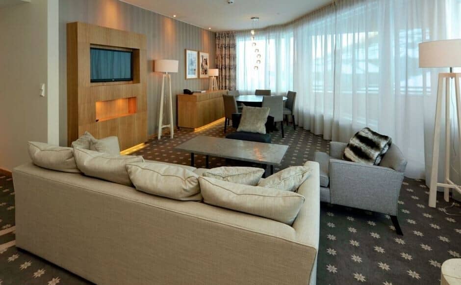 Open living area with wall-mounted TV and dining table for 4