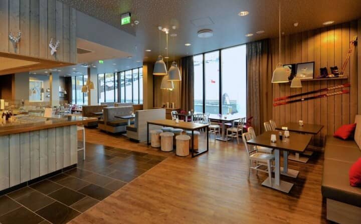 Shared dining hall with booth seating and floor-to-ceiling windows