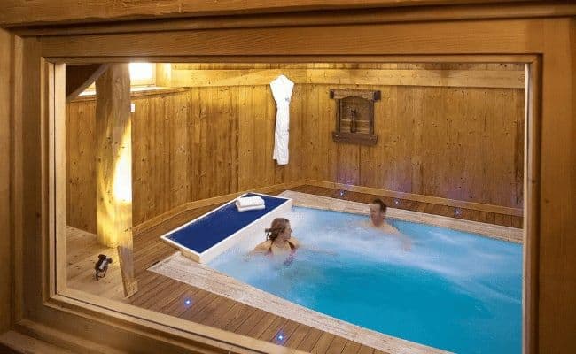 Indoor plunge pool with integrated massage jets and wooden deck