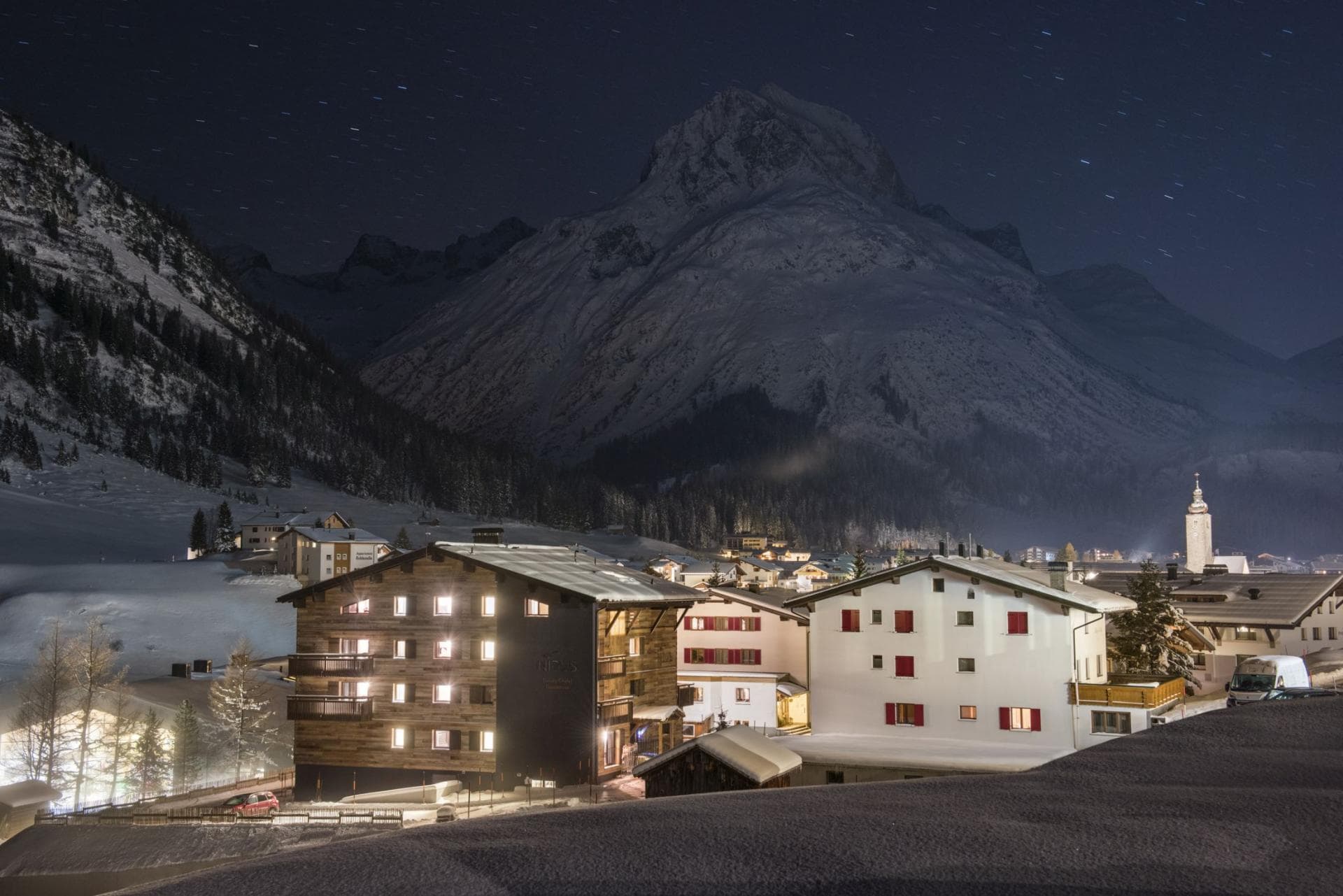 Chalet exterior at night with mountain views and village access