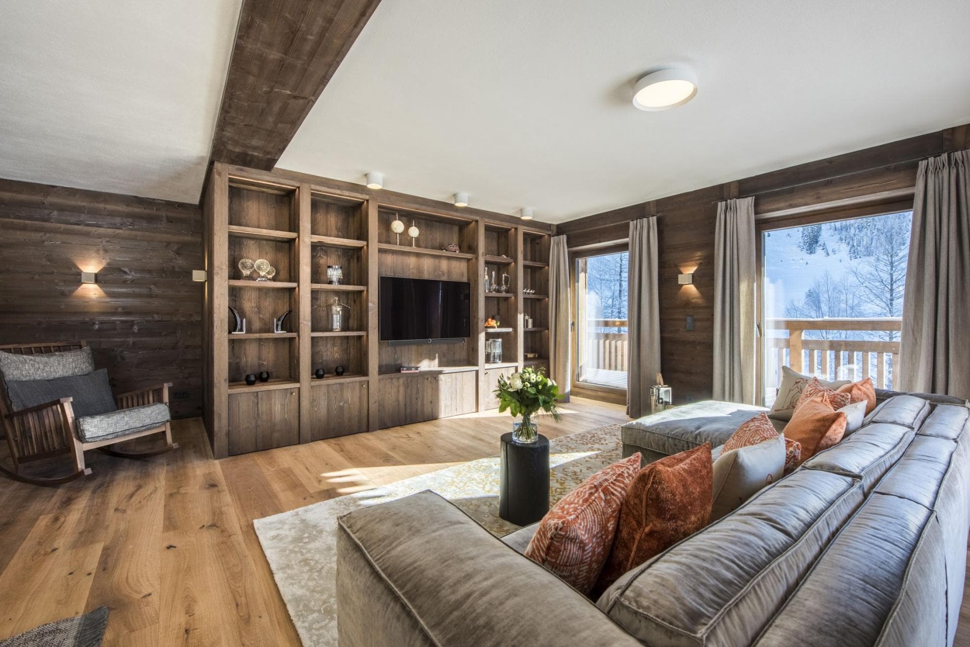 Living area with large sectional, smart TV, and balcony access