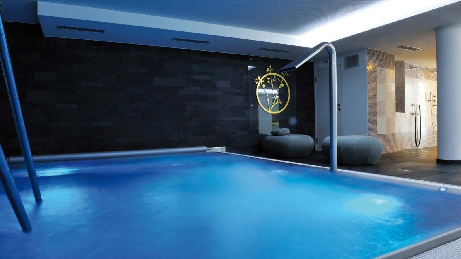 Indoor pool with glass partition; spa access visible