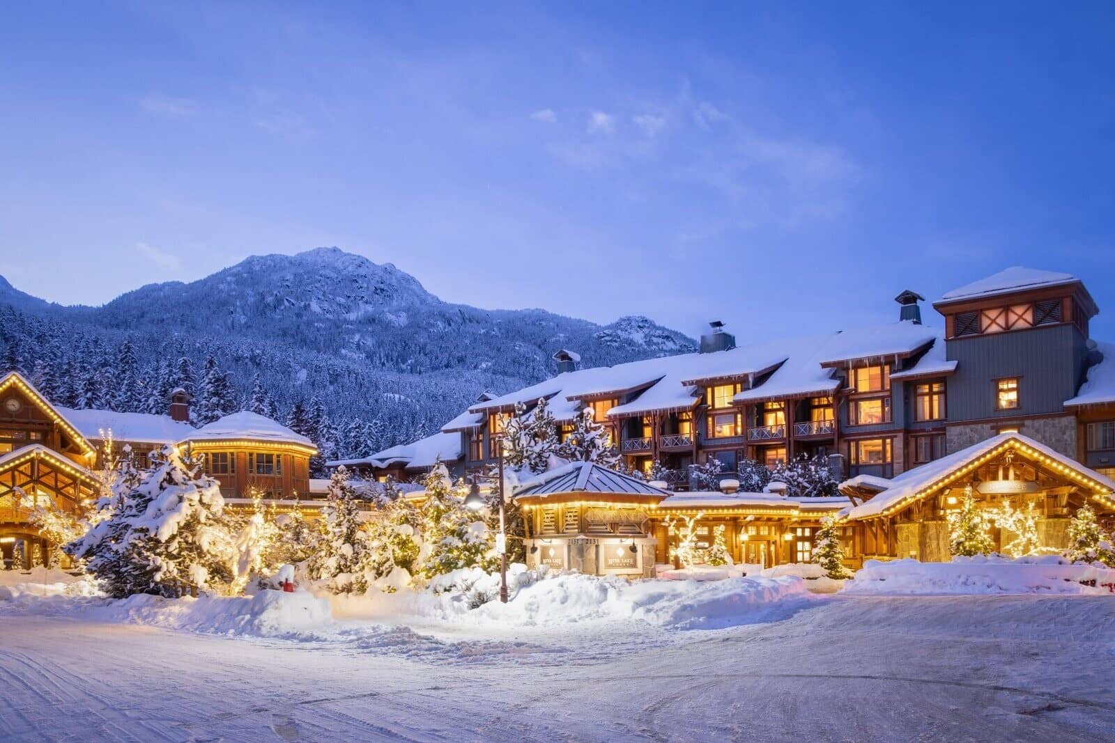 Lodge exterior featuring mountain views and illuminated snow-covered grounds