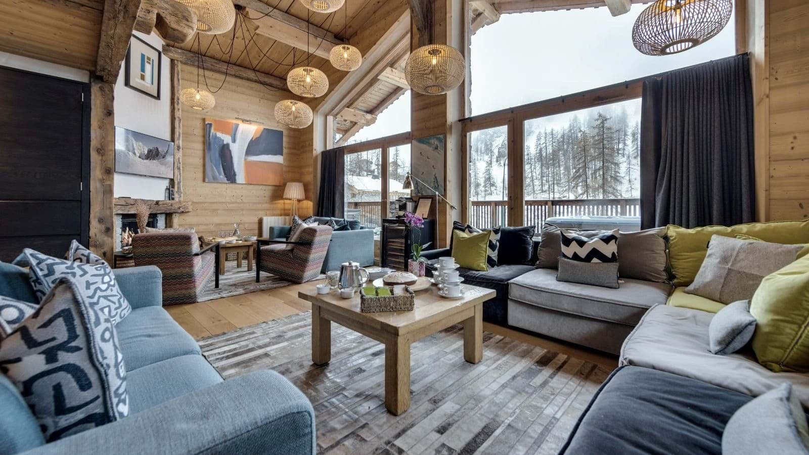 Living area with wood-burning fireplace and floor-to-ceiling forest views