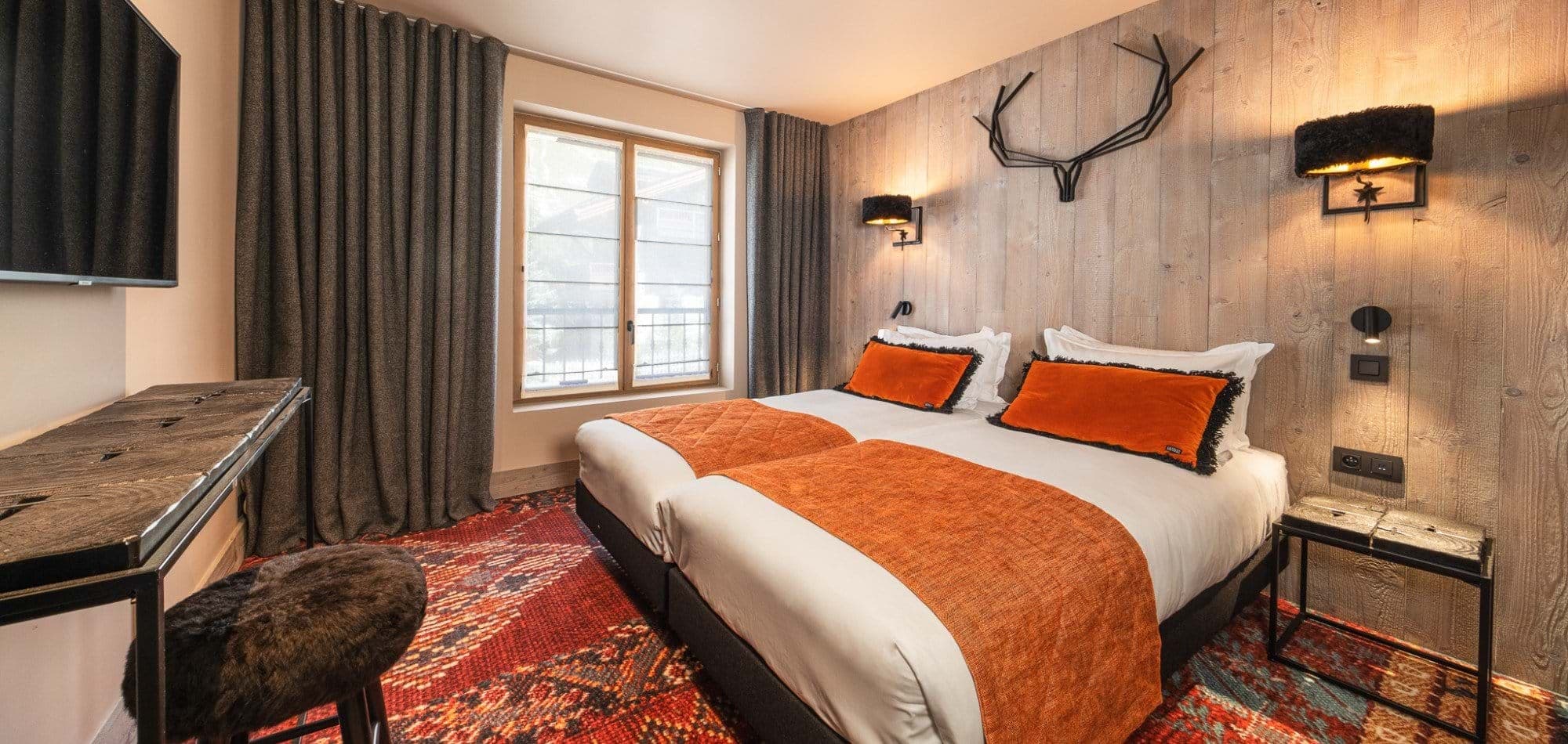 Guest bedroom with twin beds, wall-mounted TV, and workspace