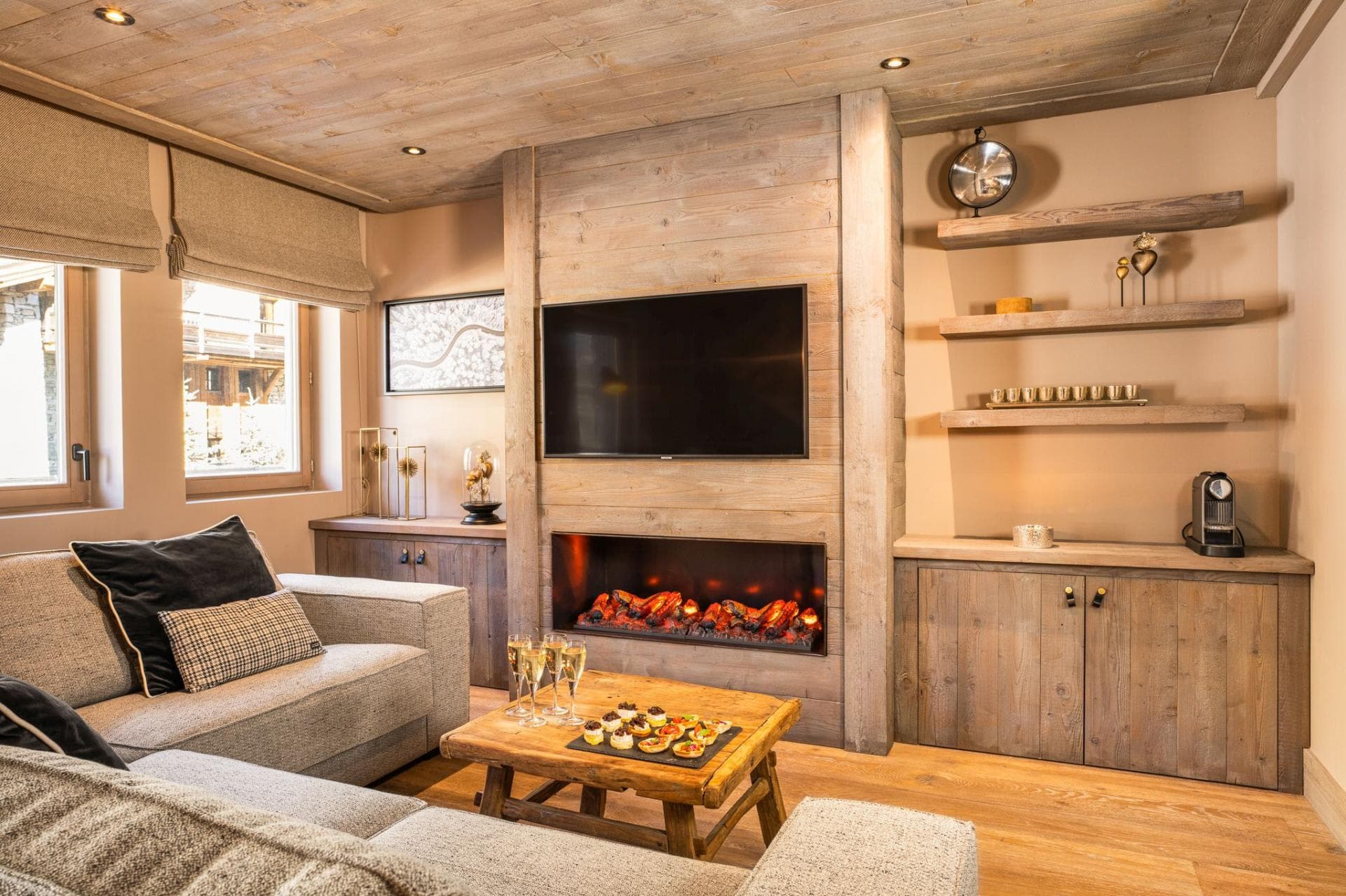 Living area with electric fireplace, wall-mounted TV, and Nespresso coffee station