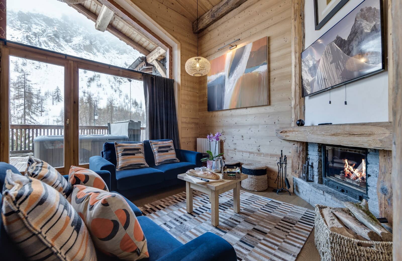 Living room with wood-burning fireplace and private deck with hot tub