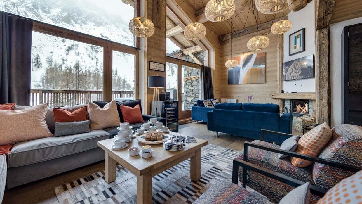 Living area with wood-burning fireplace and floor-to-ceiling mountain views
