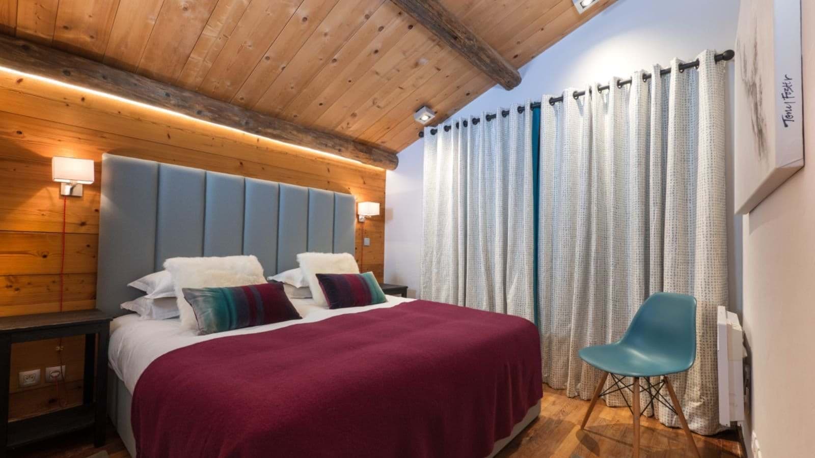 King bedroom with vaulted wood ceiling and reading lights