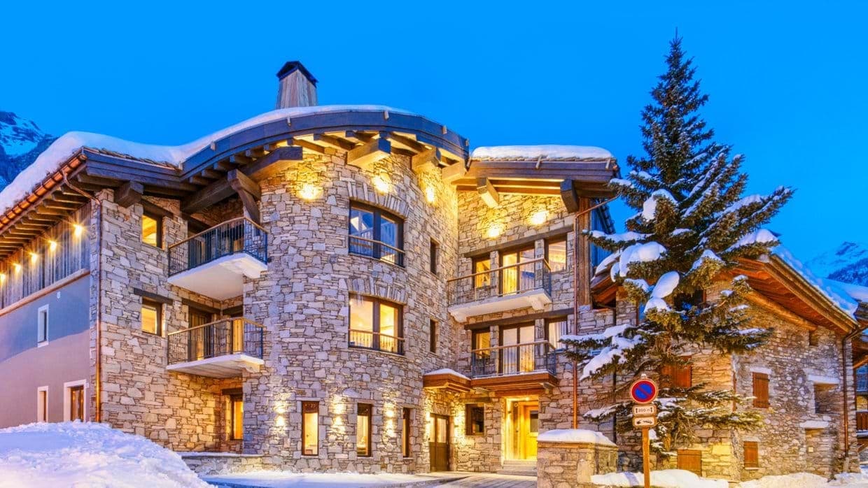 Stone chalet exterior with private balconies and heated underground entrance