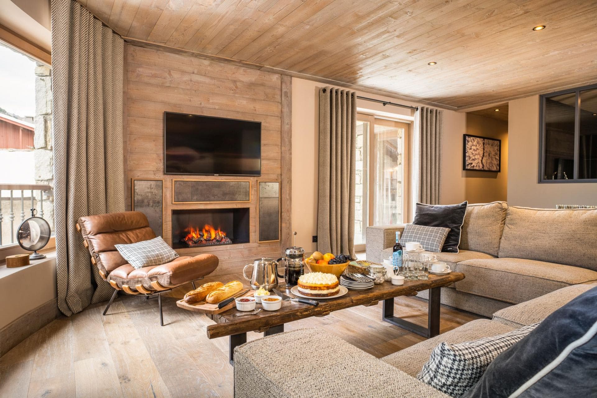 Living area with electric fireplace, wall-mounted TV, and balcony access