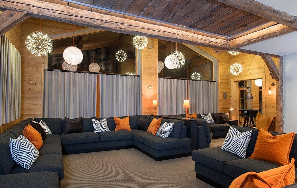 Media room with wrap-around sectional seating for 15 and reclaimed wood beams
