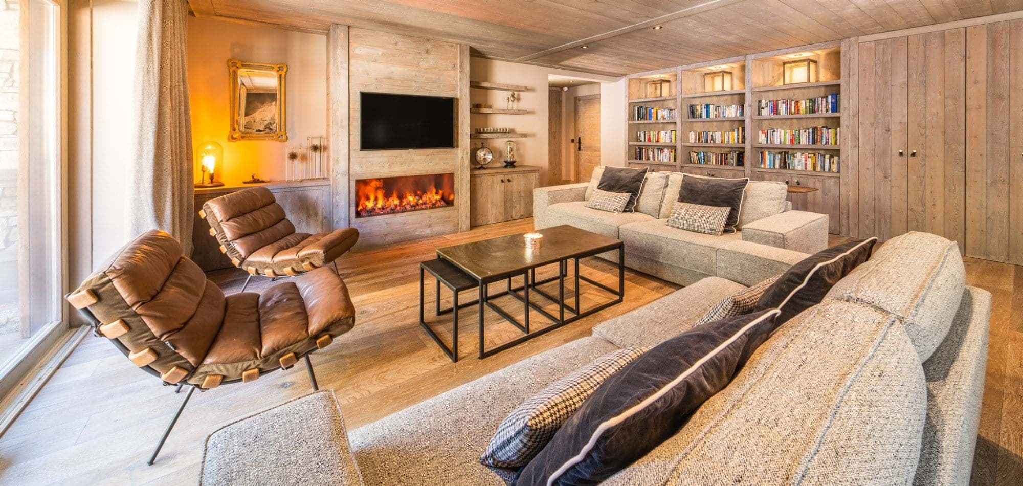 Living area with electric fireplace, library wall, and seating for 7