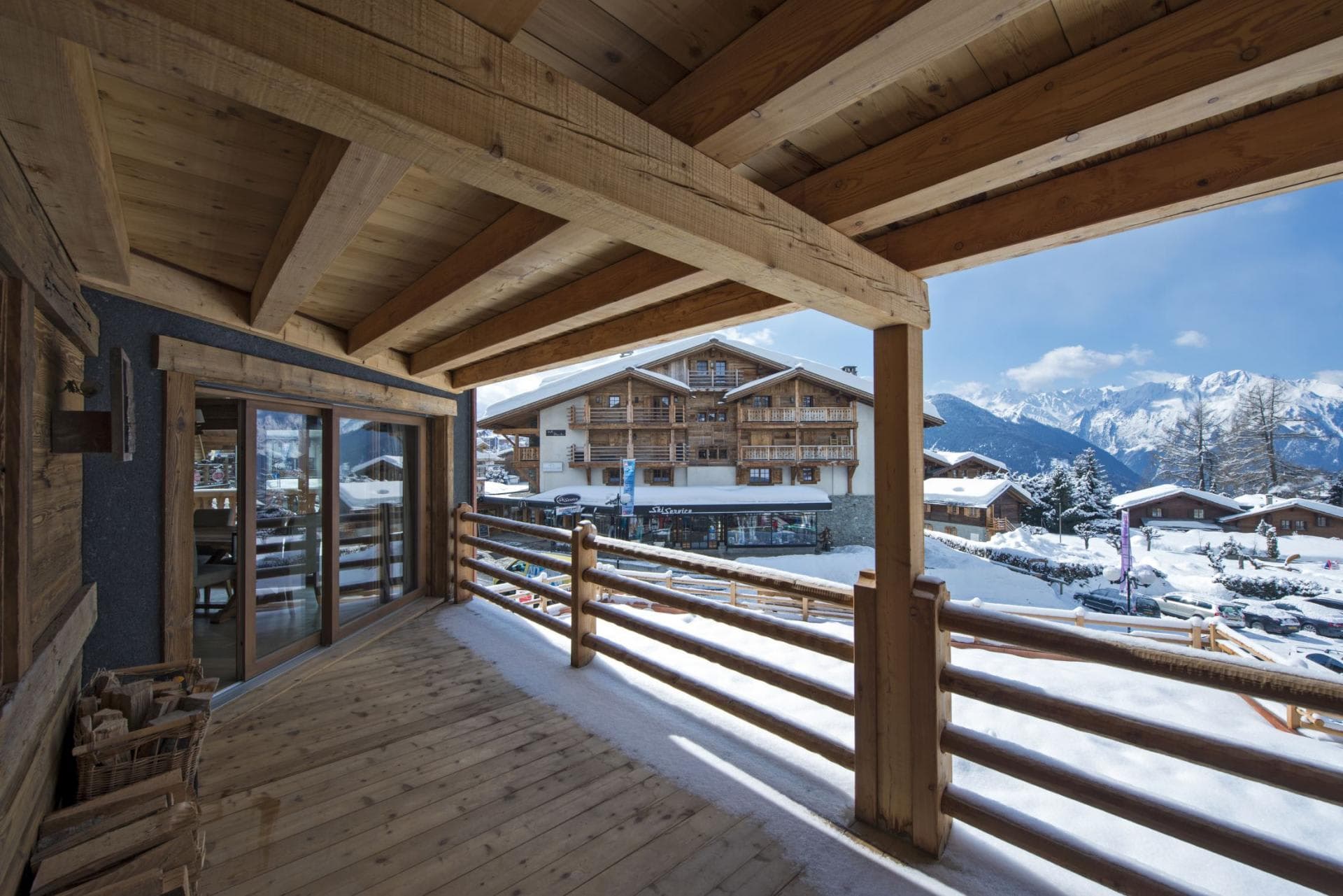 Covered wooden balcony with mountain views and firewood storage