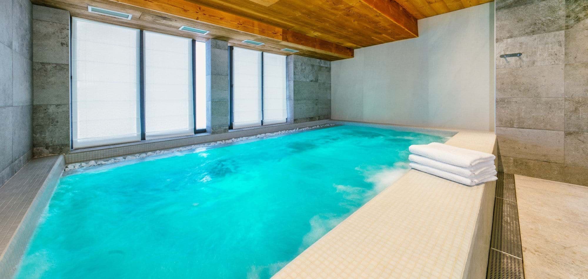 Indoor heated pool with integrated jacuzzi jets and privacy shades