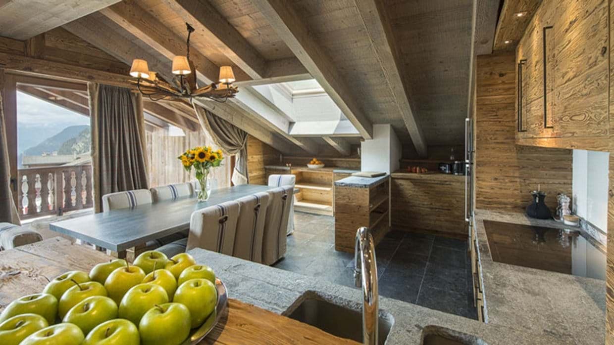 Open-plan dining area and kitchen with mountain-view balcony and skylight