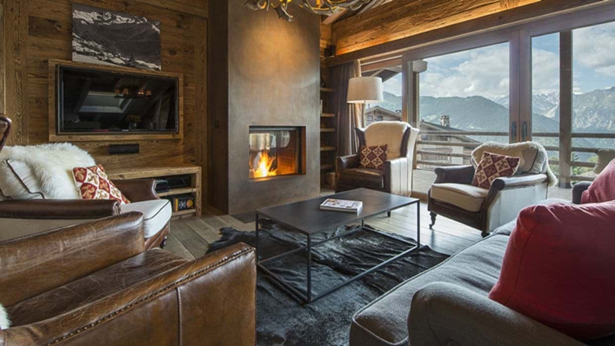 Living area with wood-burning fireplace and mountain-view balcony