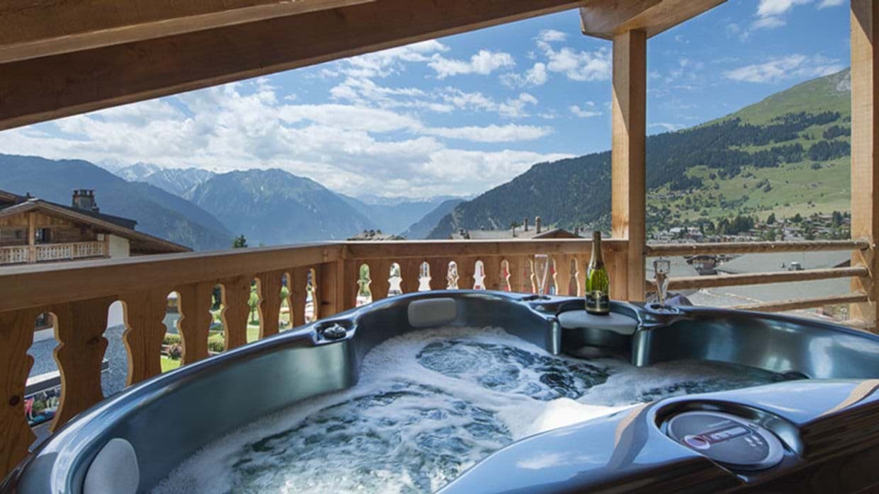 Covered balcony hot tub with panoramic mountain and valley views